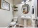 Charming half bathroom with pedestal sink, decorative mirror, and stylish wall decor, creating a cozy and inviting space at 2816 Woodlands Creek Dr, Monroe, NC 28110