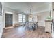 Spacious dining room with hardwood floors, a modern light fixture, and a decorative hutch at 2816 Woodlands Creek Dr, Monroe, NC 28110