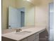 Bathroom featuring a large mirror, a white sink, and a door leading to another room at 2921 Parkwest Dr, Albemarle, NC 28001