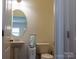 Well-lit half bath with a pedestal sink, oval mirror and a ceramic tile floor at 2921 Parkwest Dr, Albemarle, NC 28001