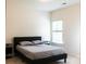 Clean bedroom showcasing a dark bed frame, simple furnishings, and a bright window for comfortable living at 2921 Parkwest Dr, Albemarle, NC 28001