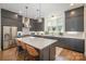 Stylish kitchen boasts gray cabinetry, stainless steel appliances, and a large center island with bar stool seating at 3026 Kalex Ct, Charlotte, NC 28204
