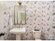 Chic powder room with floral wallpaper, pedestal sink, and gold-tone accents at 3026 Kalex Ct, Charlotte, NC 28204