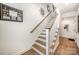 Elegant staircase with wooden steps, white risers, and a decorative wall art at 3026 Kalex Ct, Charlotte, NC 28204