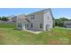 Exterior of the home featuring a well-manicured lawn, mature trees, and patio space at 321 Almora Loop, Mooresville, NC 28115