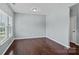 Well-lit bedroom with hardwood floors, neutral paint, large window, and a white door at 321 Almora Loop, Mooresville, NC 28115