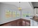 Cozy dining area with large windows, a stylish chandelier, and hardwood floors at 321 Almora Loop, Mooresville, NC 28115