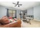 Living room with leather sofa, weight bench, shelving, and natural light from the window at 3561 Calpella Ct, Charlotte, NC 28262