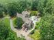Aerial view of custom home featuring an inground pool, jacuzzi, patio, 3-car garage and lush landscaping at 3587 Ridgetop Rd, Sherrills Ford, NC 28673