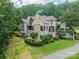 Stately home with stone accents, lush landscaping, and a private setting surrounded by mature trees at 3587 Ridgetop Rd, Sherrills Ford, NC 28673