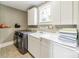 Well-lit laundry room featuring gray washer/dryer and ample counter space with storage cabinets at 3587 Ridgetop Rd, Sherrills Ford, NC 28673