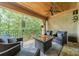 Relaxing covered patio with comfortable seating, fire pit table, and ceiling fan overlooking the lush scenery at 3587 Ridgetop Rd, Sherrills Ford, NC 28673