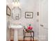 Charming half bathroom with a pedestal sink, decorative mirror, and elegant decor at 408 Johnsfield Rd, Shelby, NC 28150
