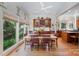 Bright dining room with a large table, chairs, hardwood floors, and many windows overlooking the outdoor landscape at 408 Johnsfield Rd, Shelby, NC 28150