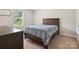 Bedroom features wood-framed bed with patterned bedding, a sunny window, neutral walls and carpet at 429 Summer Ridge Dr, Stanley, NC 28164