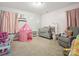 Bright bedroom with pink accents and includes a play tent, gray crib, and rocking chair at 429 Summer Ridge Dr, Stanley, NC 28164