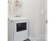 Bright laundry room showcasing modern white dryer and shelf storage for cleaning supplies at 429 Summer Ridge Dr, Stanley, NC 28164