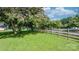Large front yard with established trees and a wooden fence, offering plenty of space at 4395 Burton Rd, Maiden, NC 28650