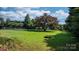 Wide shot of fenced-in grassy yard with mature trees, providing a private outdoor space at 4395 Burton Rd, Maiden, NC 28650
