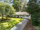 Landscaped front yard of a traditional home with a long driveway and mature trees at 5329 Valley Forge Rd, Charlotte, NC 28210
