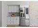 Kitchen area features stainless steel refrigerator, white cabinets, and a white tile backsplash at 5329 Valley Forge Rd, Charlotte, NC 28210
