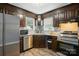 Well-lit kitchen featuring stainless steel appliances and dark wood cabinetry at 656 Ne Camrose Ne Cir, Concord, NC 28025
