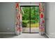 View of well maintained backyard through sliding glass doors with floral curtains at 656 Ne Camrose Ne Cir, Concord, NC 28025