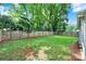 Fenced backyard with a well maintained lawn and mature trees at 6705 Reddman Rd, Charlotte, NC 28212
