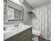 Bathroom featuring a shower with patterned curtain, modern vanity, and wood shelf at 6705 Reddman Rd, Charlotte, NC 28212