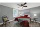 Cozy bedroom showcasing a ceiling fan, natural light, and gray toned walls at 6705 Reddman Rd, Charlotte, NC 28212