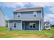 Exterior back of house features a covered porch and expansive lawn at 7129 Jerimoth Dr, Charlotte, NC 28215