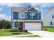 Two-story home featuring blue siding, stone accents, and a two-car garage at 7129 Jerimoth Dr, Charlotte, NC 28215