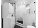 Sleek bathroom featuring white subway tile, a black-tiled shower, a sink, and a stacked washer dryer at 715 N Church St # 513, Charlotte, NC 28202