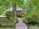Back of the home featuring a deck, screened-in porch, and a bridge leading to the grassy backyard at 715 White Oaks Cir, Monroe, NC 28110