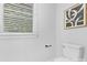 Bright bathroom with a white toilet, white walls, a dark towel bar, and a window with blinds for a fresh, clean aesthetic at 715 White Oaks Cir, Monroe, NC 28110