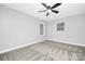 Spacious bedroom with two windows, a ceiling fan and neutral carpet, providing a versatile space at 715 White Oaks Cir, Monroe, NC 28110
