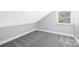 Attic bedroom with natural light and carpeted floors, offering a cozy and inviting space at 715 White Oaks Cir, Monroe, NC 28110