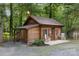 Cozy cabin exterior with rocking chairs, flower boxes, and natural wood siding nestled amongst lush greenery at 715 White Oaks Cir, Monroe, NC 28110