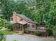 Charming cabin-style home with a screened porch and wooden deck nestled in a lush, wooded setting at 715 White Oaks Cir, Monroe, NC 28110
