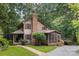 Charming two-story wood home with a covered front porch, a screened-in porch, and a lovely brick chimney at 715 White Oaks Cir, Monroe, NC 28110