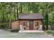 Charming cabin exterior with a cozy front porch, rocking chairs, flower-filled window boxes, and natural wood siding at 715 White Oaks Cir, Monroe, NC 28110