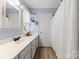 Bright bathroom featuring a single sink vanity, quartz countertops, and decorative framed mirrors at 7425 Hubbard Woods Rd, Charlotte, NC 28269