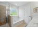 Bright bathroom featuring a glass shower, soaking tub, and large window at 78114 Rillstone Dr, Lancaster, SC 29720