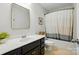Bathroom featuring dark cabinets, a framed mirror, and tub with shower at 78114 Rillstone Dr, Lancaster, SC 29720