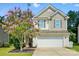 Inviting home featuring vinyl and shingle siding, a two-car garage, and a lovely flowering tree at 78114 Rillstone Dr, Lancaster, SC 29720