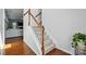 Carpeted staircase with white and wood railing, with hardwood floors and a glimpse into the living area at 78114 Rillstone Dr, Lancaster, SC 29720