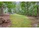 View of the backyard with mature trees and partial home view at 870 Family Dr, Midland, NC 28107