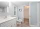 Clean bathroom featuring a white vanity, toilet, and medicine cabinet, complemented by neutral vinyl flooring and soft light blue walls at 870 Family Dr, Midland, NC 28107