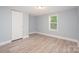 Neutral bedroom with wood-look floors, white door and trim at 870 Family Dr, Midland, NC 28107