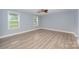 Comfortable bedroom featuring light blue walls, neutral vinyl floors, and natural light from two windows, creating a soothing space at 870 Family Dr, Midland, NC 28107